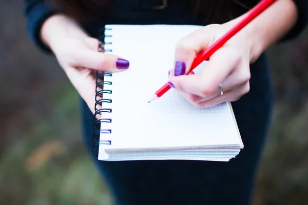 Fille écrit dans un cahier — Photo