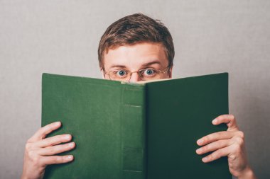 Adam yüzünü bir kitap ile kaplı