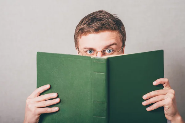 Man vallen zijn gezicht met een boek — Stockfoto