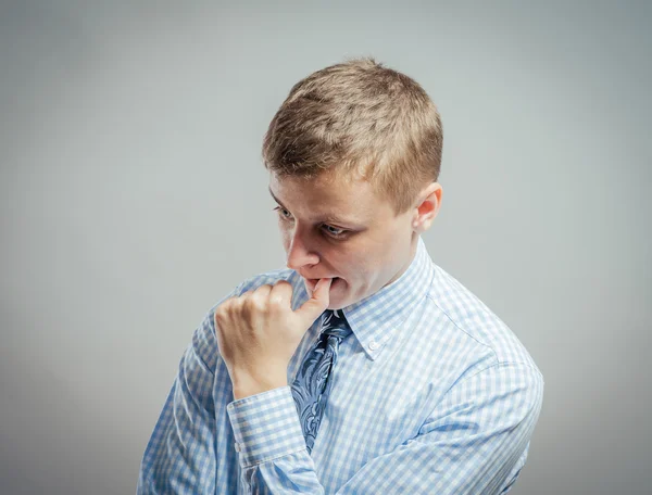 Man biting his thumb fingernail — Stock Photo, Image