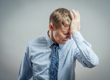 Baş ağrısı olan genç bir adam.