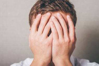 adam eliyle yüzünü kapsayan