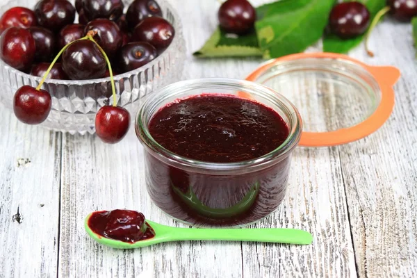 Mermelada de cereza orgánica casera y cerezas a su alrededor — Foto de Stock