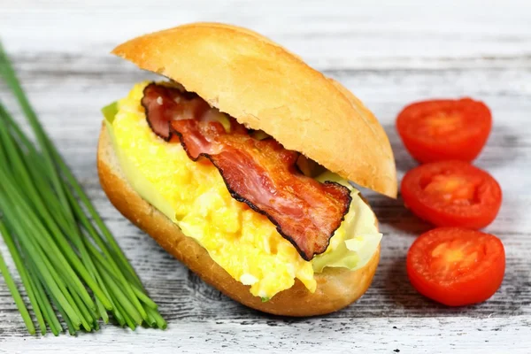 Delizioso panino con pancetta, uova strapazzate e lattuga — Foto Stock