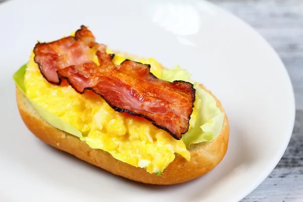 Delicioso sándwich con tocino, huevo revuelto y lechuga —  Fotos de Stock