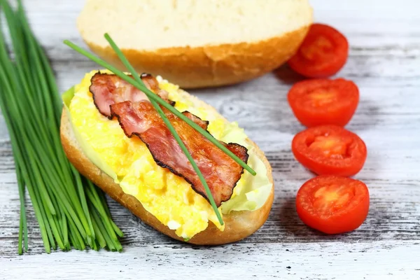 Sanduíche delicioso com bacon, ovo mexido e alface — Fotografia de Stock