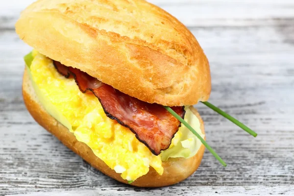 Delizioso panino con pancetta, uova strapazzate e lattuga — Foto Stock