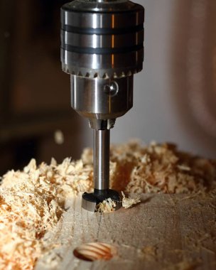 Talaş tozuyla değirmen biçme makinesi çalışıyor. Tahtada delikler açan değirmen makinesine yaklaşıyoruz.