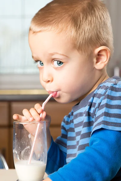 Lindo niño bebe leche usando una pajita — Foto de Stock
