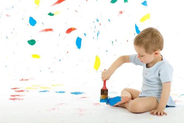 Bedårande 3-årig pojke barn fläckar kreativt på väggen. Stockbild