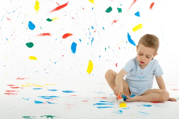 Bedårande 3-årig pojke barn fläckar kreativt på väggen. Royaltyfria Stockfoton