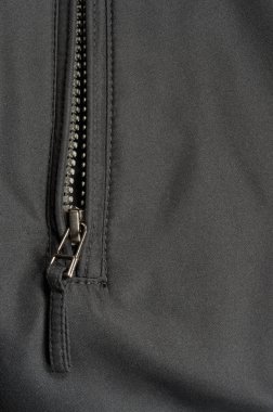 Siyah polyester dimi kumaş doku arka plan, açık ceket fermuar çekme ayrıntı, dokulu kumaş, makro closeup, büyük detaylı açılan fermuarlı cep dikey studio vurdu