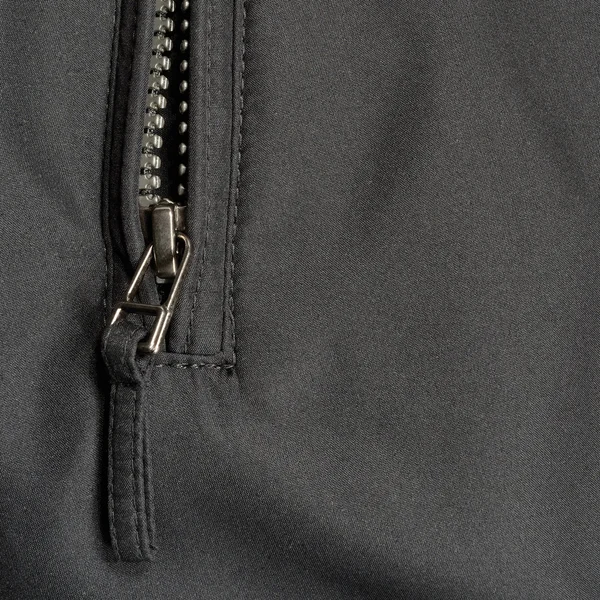 Black polyester twill fabric texture background, open jacket zipper pull detail, textured textile, macro closeup, large detailed opened zippered pocket vertical studio shot — Stock Photo, Image