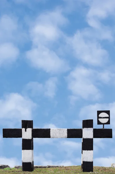 Dead end no through train railroad traffic sign weathered old grungy railway stop symbol signal signage, black and white striped retro barrier closeup vertical cloudscape background summer sky clouds — Stock Photo, Image