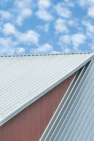 Industrial building roof sheets, grey steel rooftop pattern, bright summer  clouds cloudscape, blue sky, rifled roofing