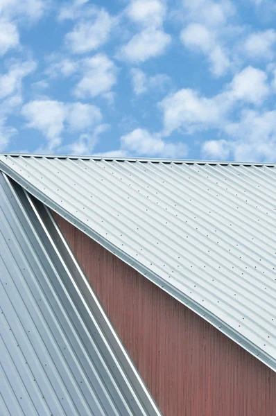 Dachbleche für Industriegebäude, graues Stahldachmuster, helle Sommerwolken Wolkenlandschaft, blauer Himmel, geriffelte Dachplatten, große detaillierte ockerfarbene Holzstruktur, strukturierter Bauhintergrund, rote ockerfarbene Holzwandnahaufnahme, vertikal — Stockfoto