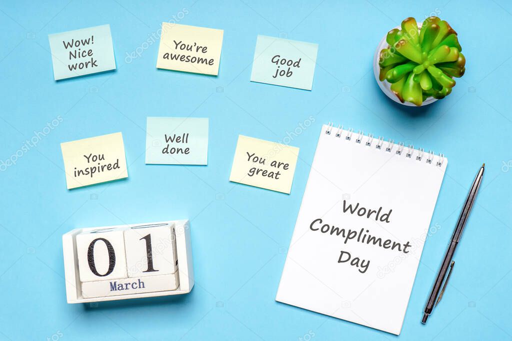 Happy World Compliment Day. Office desk with plant, notebook, pen and paper slips with compliments text for office worker such as GOOD JOB. Calendar date 1 March, greeting card. Flat lay, top view.