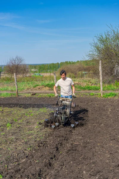 Man Wellingtons Met Cultivator Ploegen Grond Zonnige Dag Landbouw Bodembewerking — Stockfoto