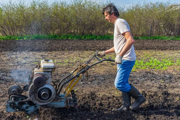 Man Wellingtons Met Cultivator Ploegen Grond Zonnige Dag Landbouw Bodembewerking — Stockfoto
