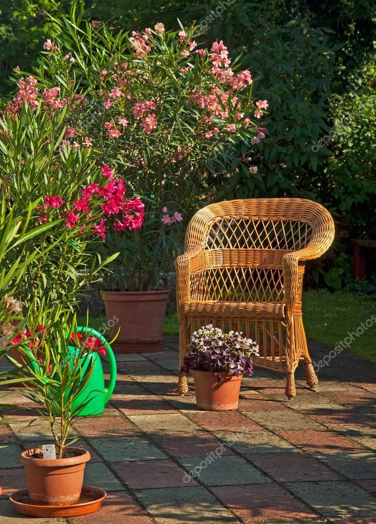 Sillas de madera en un jardín con flores en él. — Foto de stock