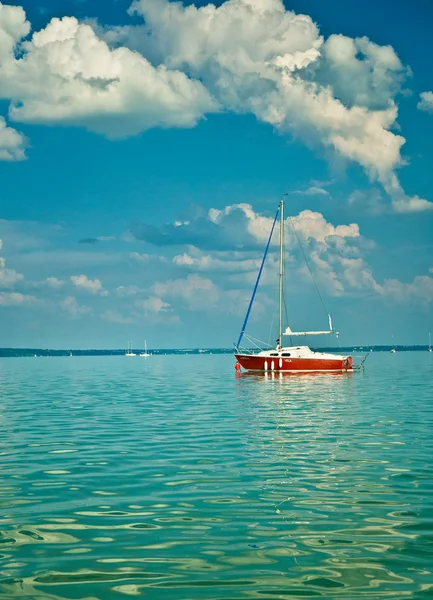 Красный парусник на озере — стоковое фото