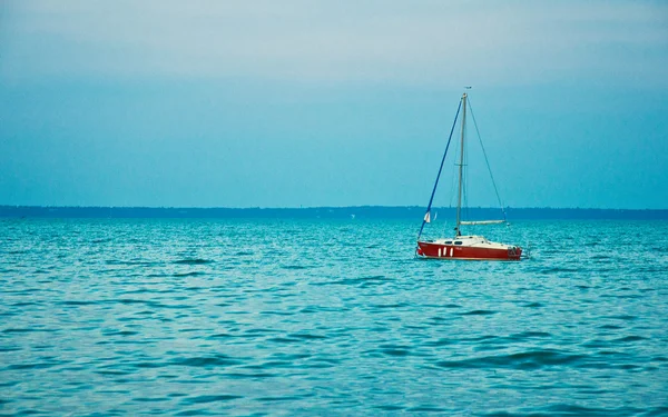 Red sailboat on lake — Stock Photo, Image