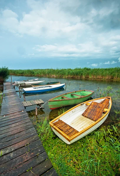 Деревянные лодки возле пирса — стоковое фото