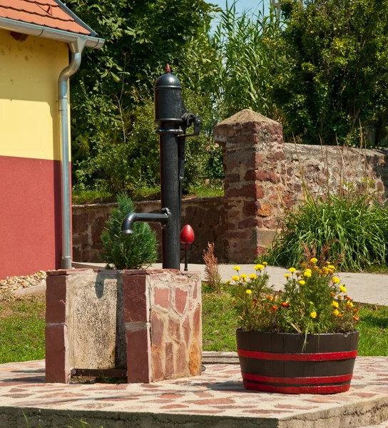 Well with water tap and flowerpot in the old town of Szeged — Stock Photo, Image