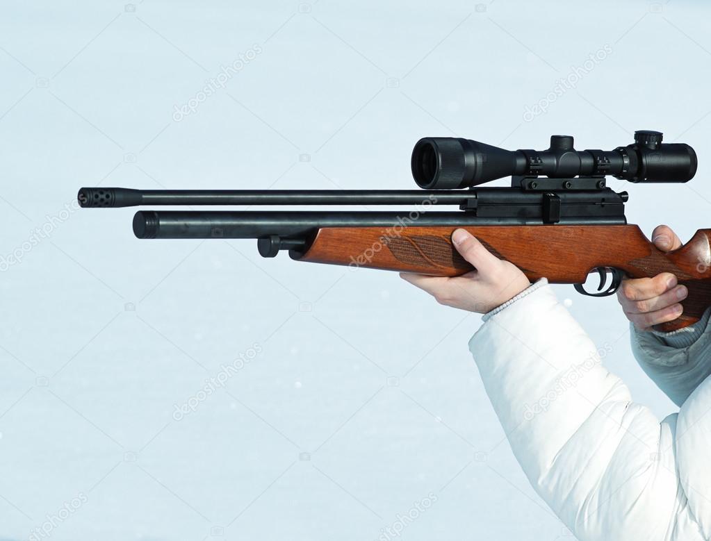 Man with optical rifle in winter