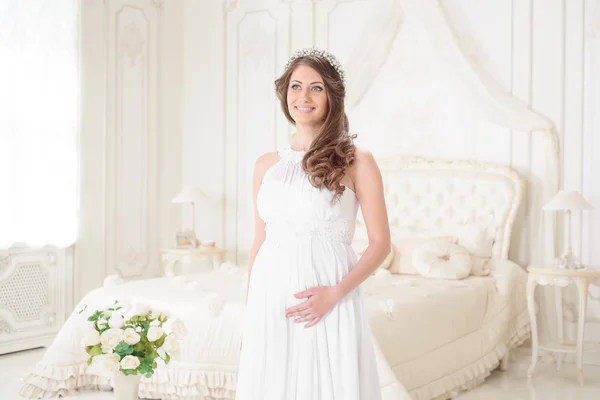 Glad gravid kvinna i en ljus interiör — Stockfoto