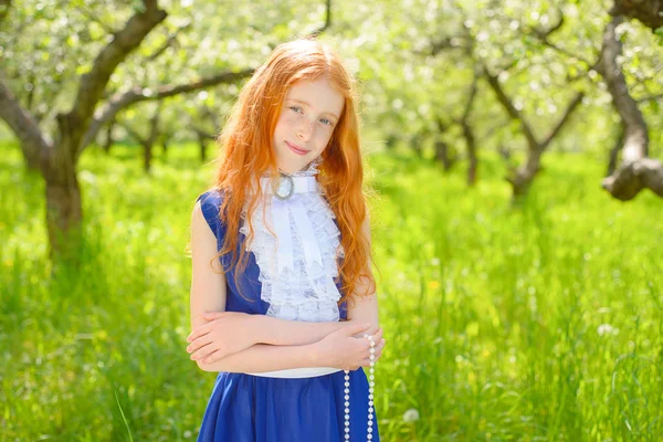 Red-haired girl in a sunny garden — Stock Photo, Image