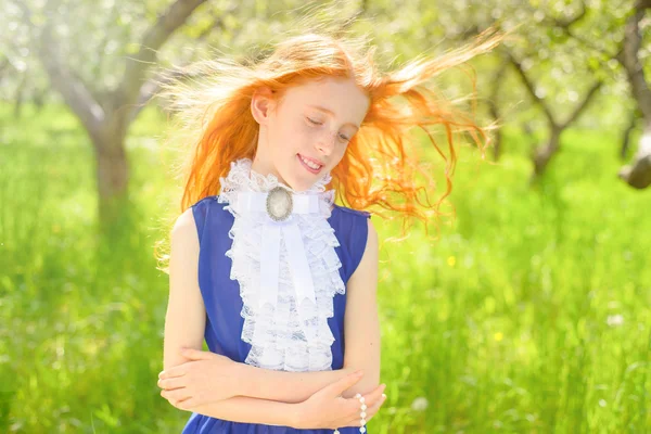 Red-haired girl in a sunny garden — Stock Photo, Image