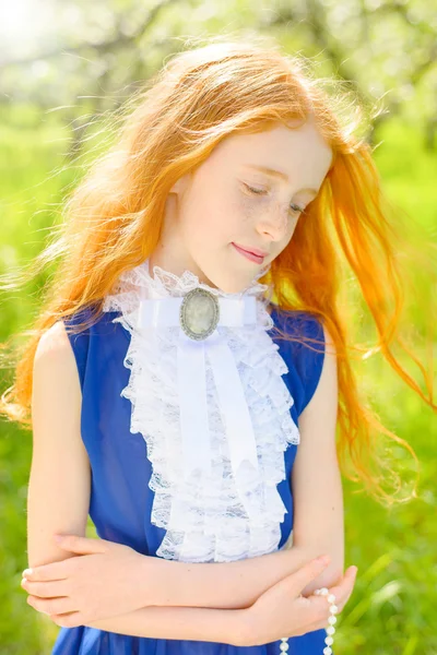Red-haired girl in a sunny garden — Stock Photo, Image