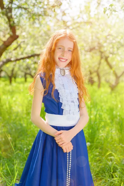 Rödhårig tjej i en solig trädgård — Stockfoto