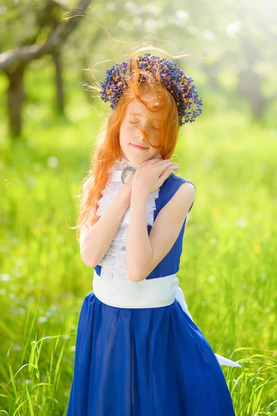 Red-haired girl in a sunny garden — Stock Photo, Image