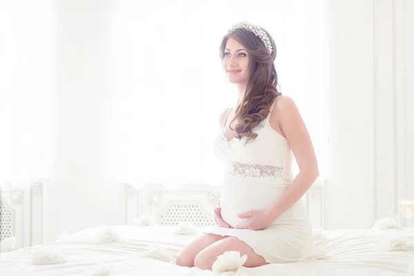 Gelukkig zwangere vrouw in een licht interieur — Stockfoto