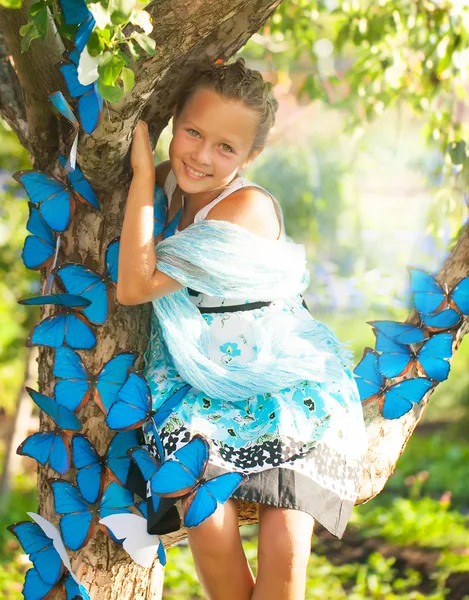 Jong meisje met blauwe vlinders — Stockfoto