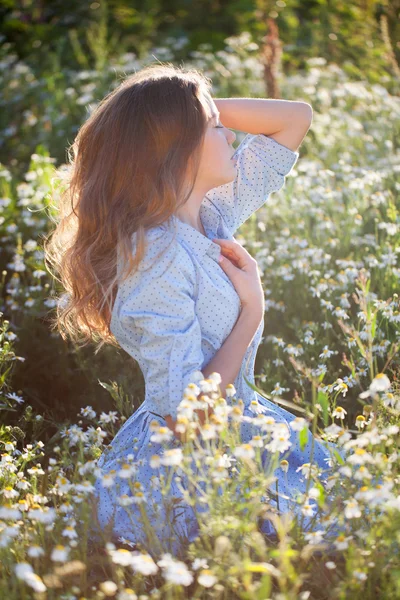 Hermosa mujer joven acostada en la hierba y la flor que huele , —  Fotos de Stock