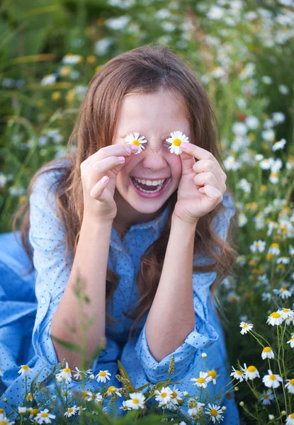 Hermosa mujer joven acostada en la hierba y la flor que huele , — Foto de Stock