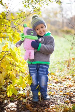 Parkta düşen yapraklarla oynayan çocuklar