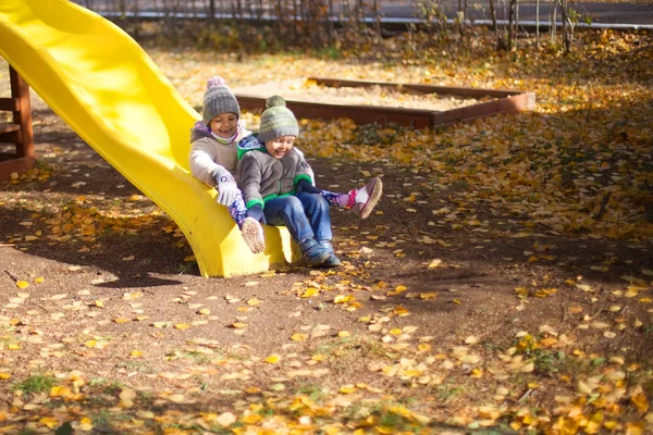 Crianças brincando com outono caído folhas no parque — Fotografia de Stock