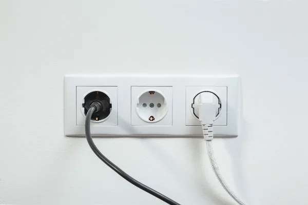 Tomadas de energia conectadas em uma tomada elétrica — Fotografia de Stock
