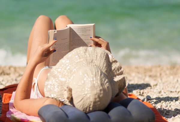 leisure young girl reading a book at beach