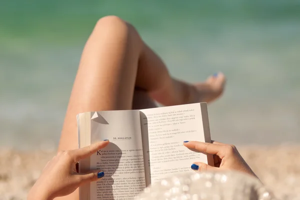 Jong meisje vrije tijd lezen van een boek op strand — Stockfoto