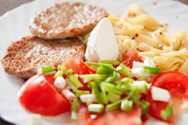 köfte, domates, makarna ve salata yemek tabağı