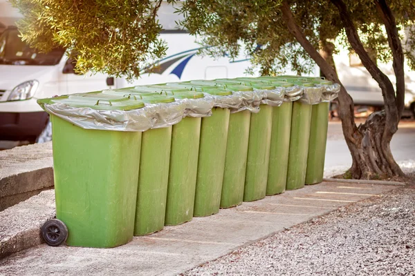 Nine green containers collectiong trash at camp — Stock Photo, Image