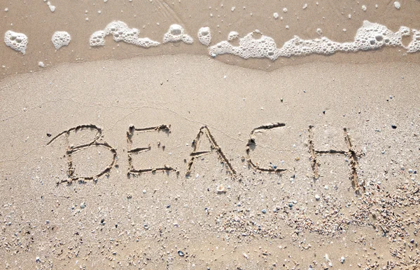 Handwriting word beach at sea beach sand — Stock Photo, Image