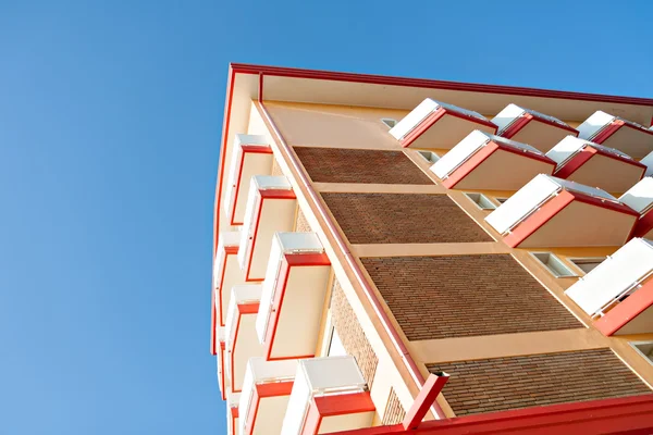 Архітектура багатоквартирного будинку з балконом на блакитному небі Стокове Фото
