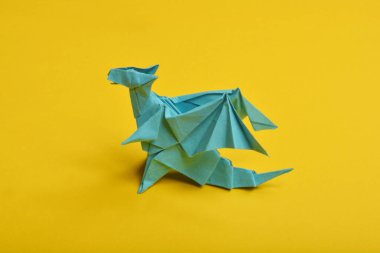 Sarı arkaplanda mavi origami kağıt ejder