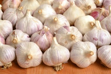 Tahta masada bir sürü sarımsak soğanı var.